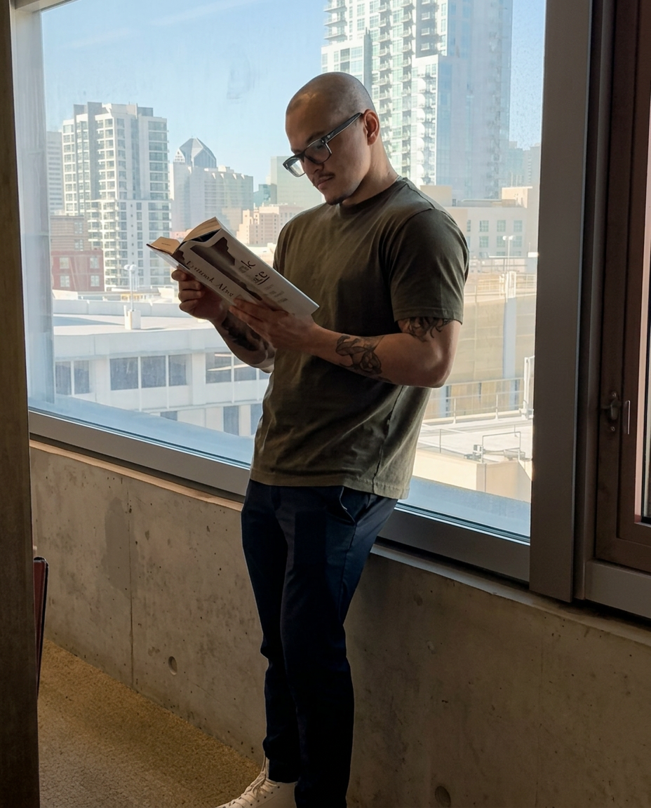 Man reading beside a window